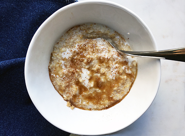 Buttermilk steel cut oatmeal in a white bowl with a spoon.