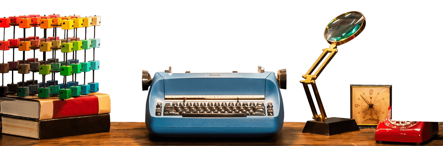 Blue vintage typewriter on a desk with a magnifying glass, and a clock