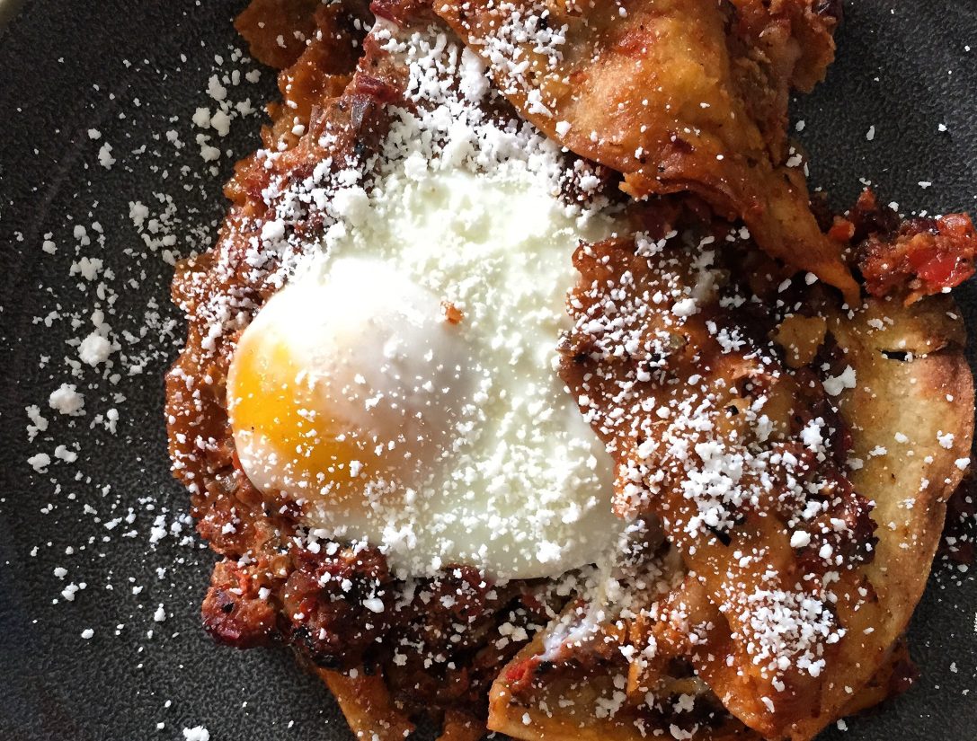 Chilaquiles topped with an over-easy egg.
