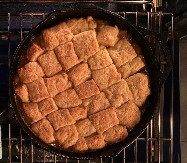 Peach cobbles in a cast-iron skillet.