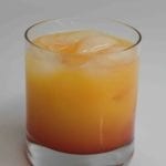 Tequila sunrise with ice in a rocks glass.