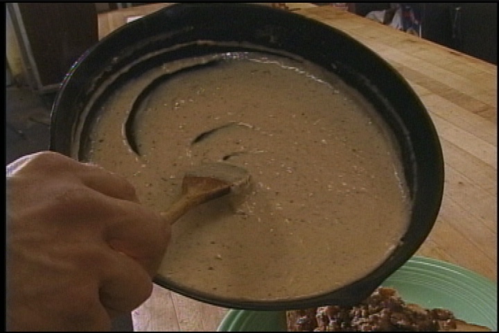 Sawmill gravy in a cast-iron skillet on the set of Good Eats.