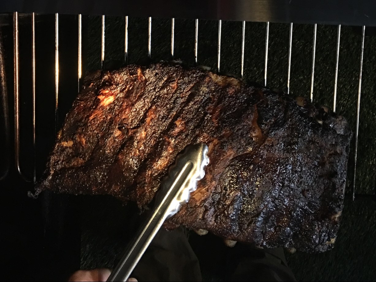 Barbecue St. Louis pork ribs on a grill grate.