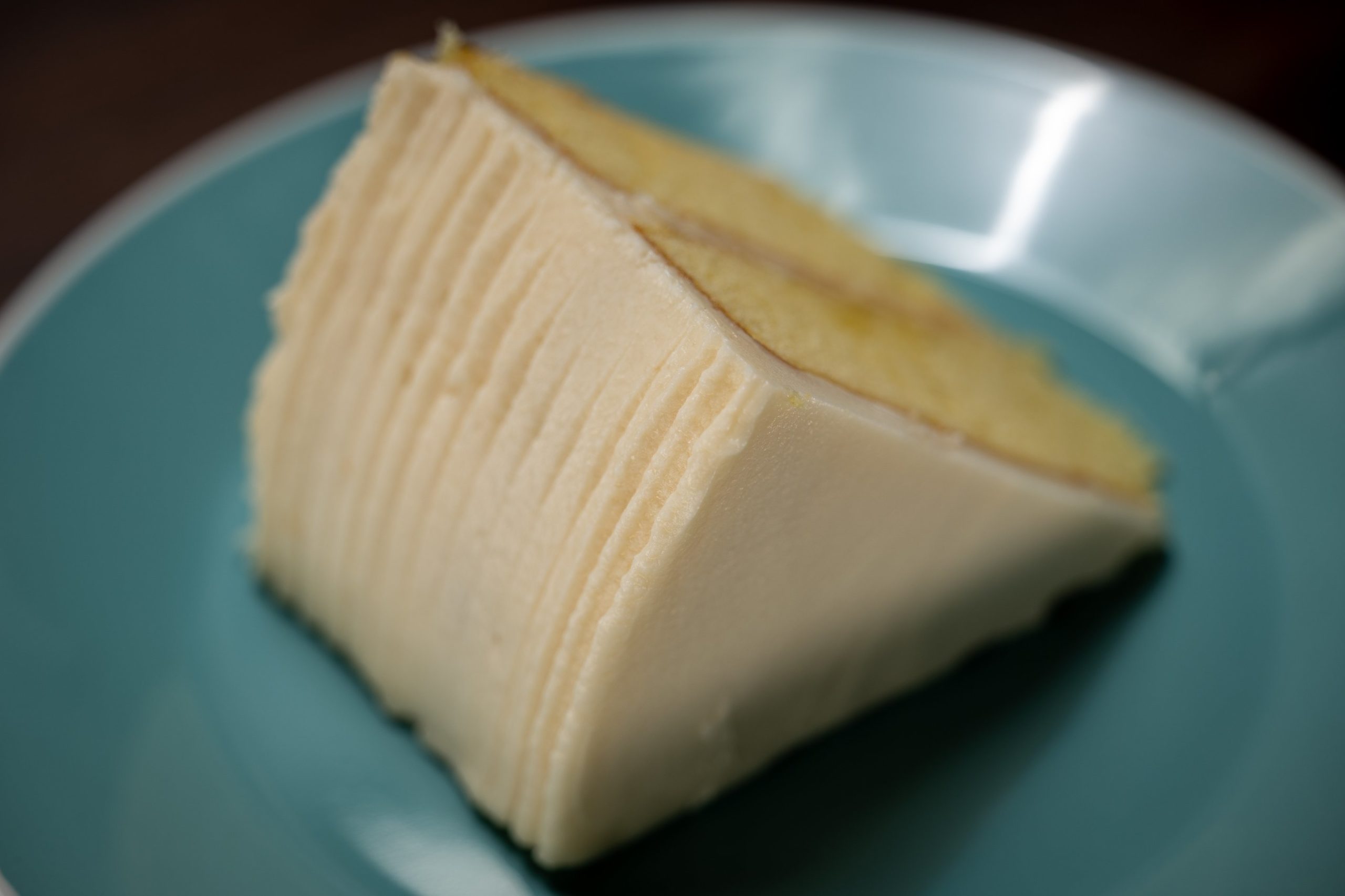 American Butter(milk)cream on a slice of Alton Brown's gold cake plated on teal plate.