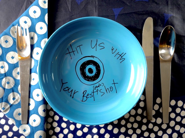 A blue pate with the words "hit us with your best photo shot" written in Alton Brown's handwriting.