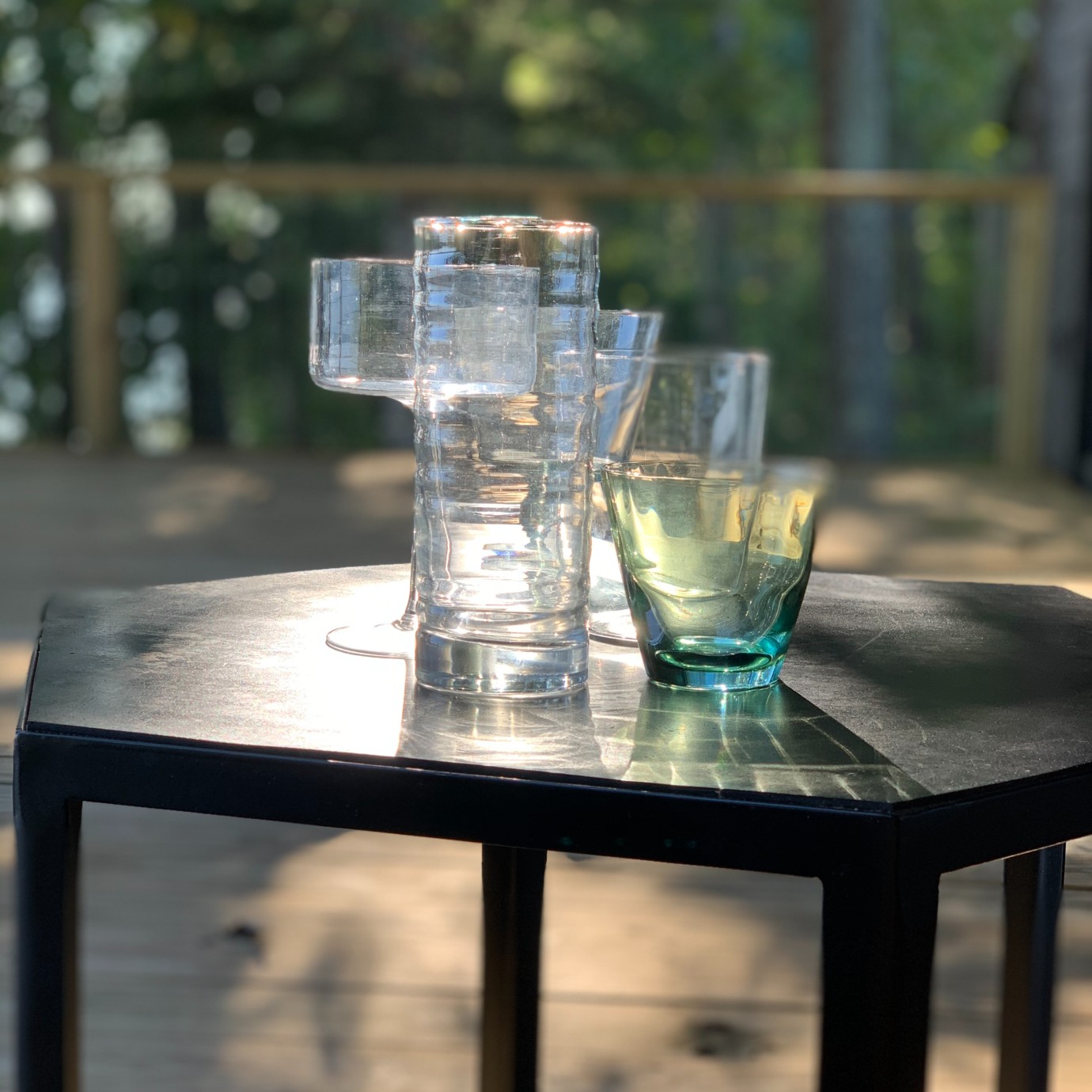 Alton Brown's cocktail glasses displayed outdoors on a black end table.