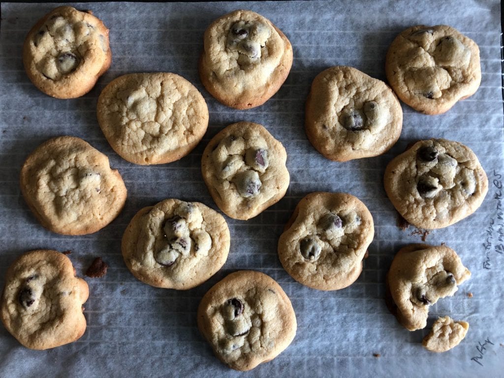 The Puffy chocolate chip cookies on a parchment paper-lined wire rack.