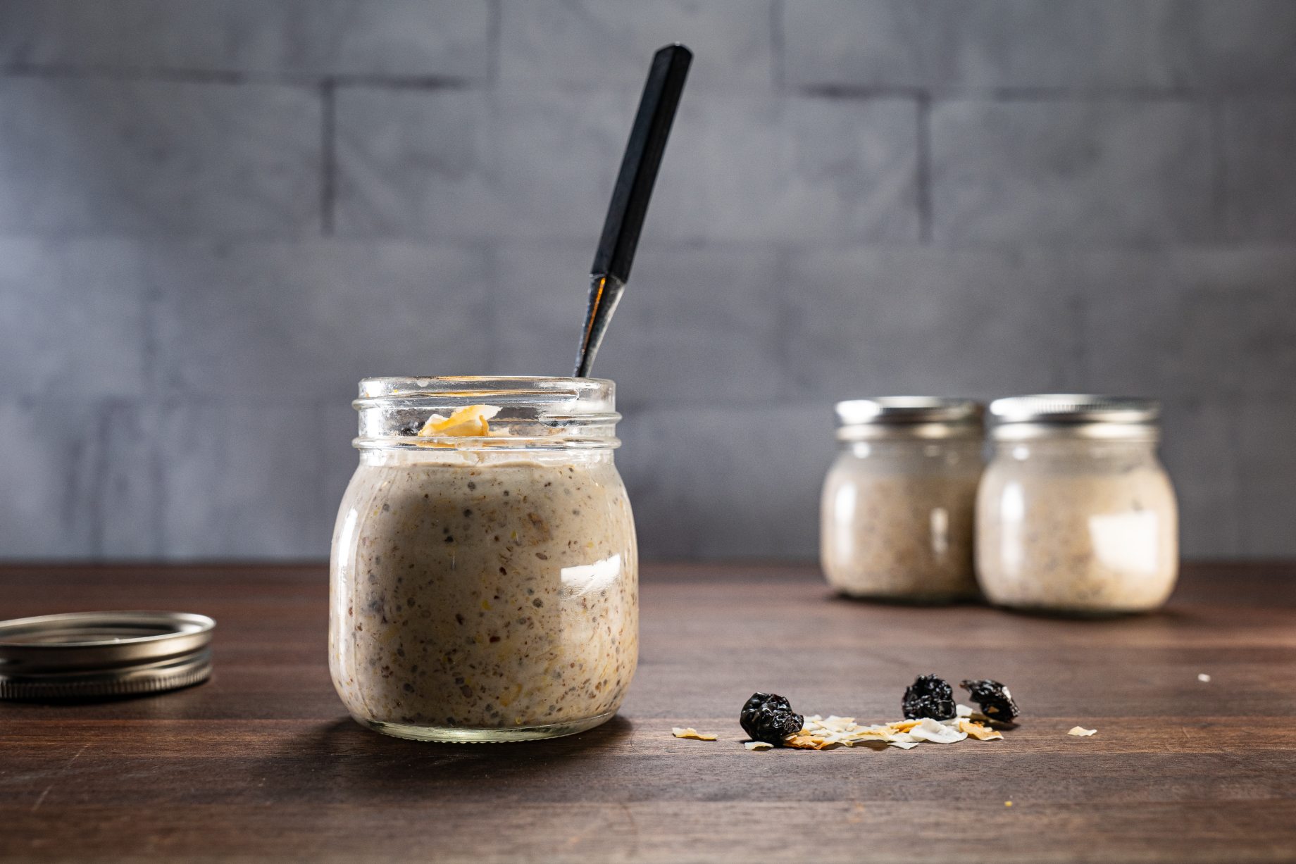 Overnight coconut oats in a small mason jar with a spoon.