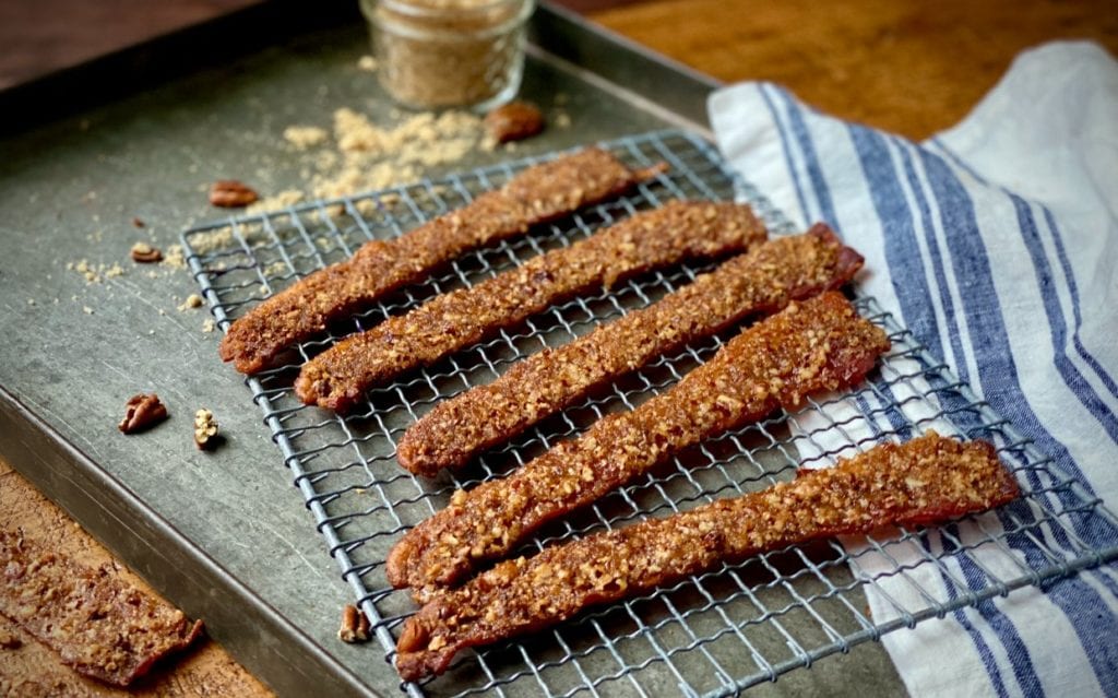 Praline bacon slices on a wire cooling rack.