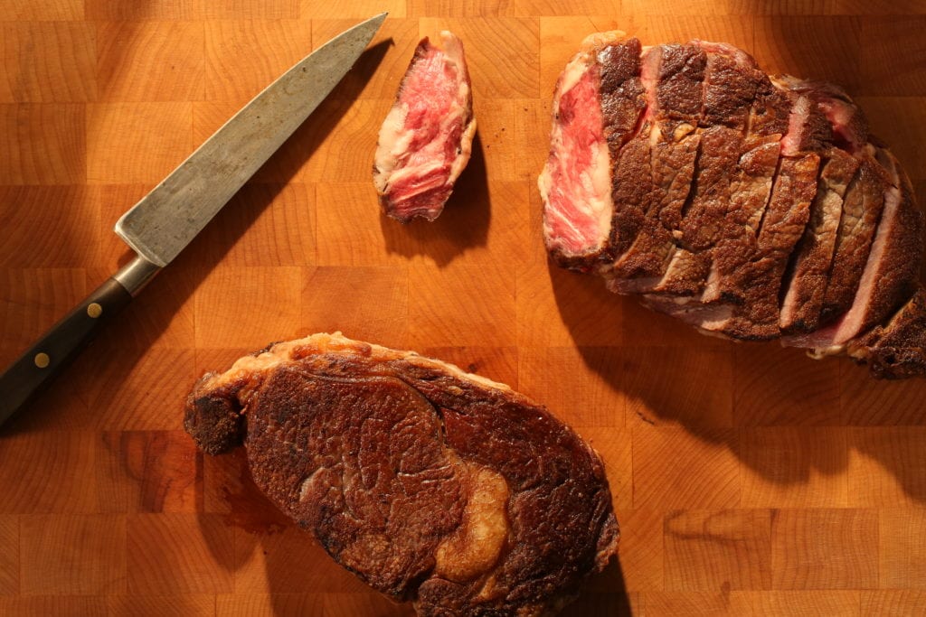 Pan-seared ribeye on a butcher block cutting board