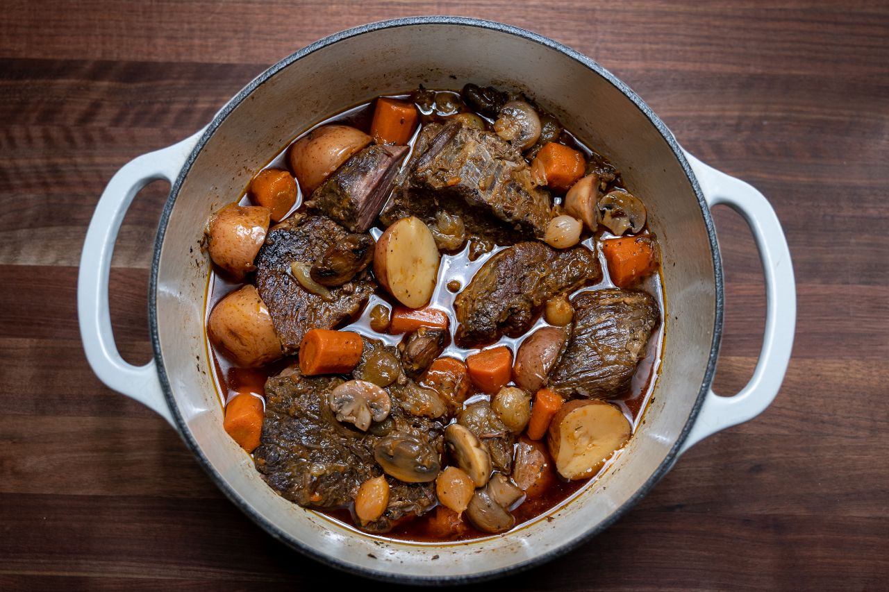 The final pot roast with potatoes and carrots in a Dutch oven.