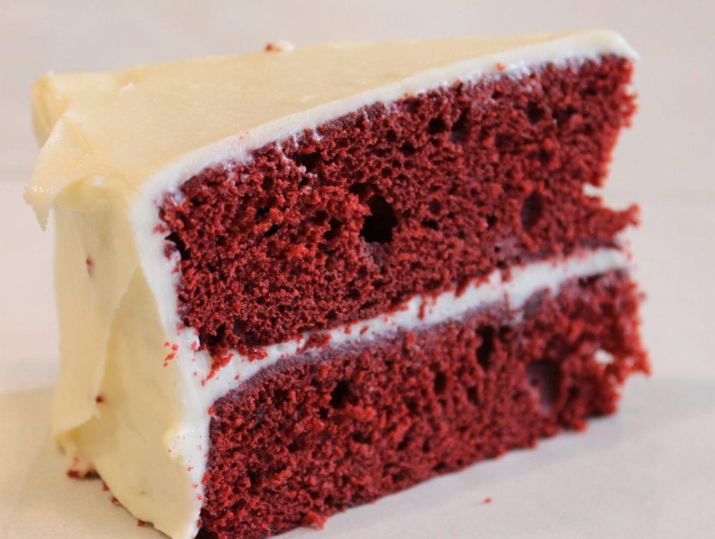 Red velvet cake slice with cream cheese frosting.