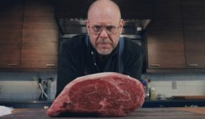 Alton Brown in his kitchen with a three-bone holiday standing rib roast.